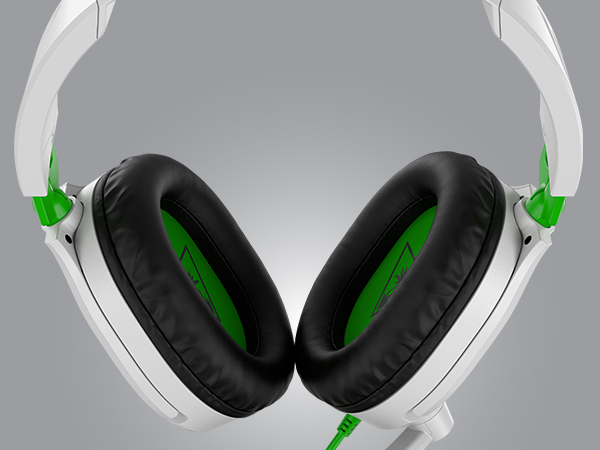 Auriculares para juegos blancos y verdes con cojines negros sobre fondo gris.