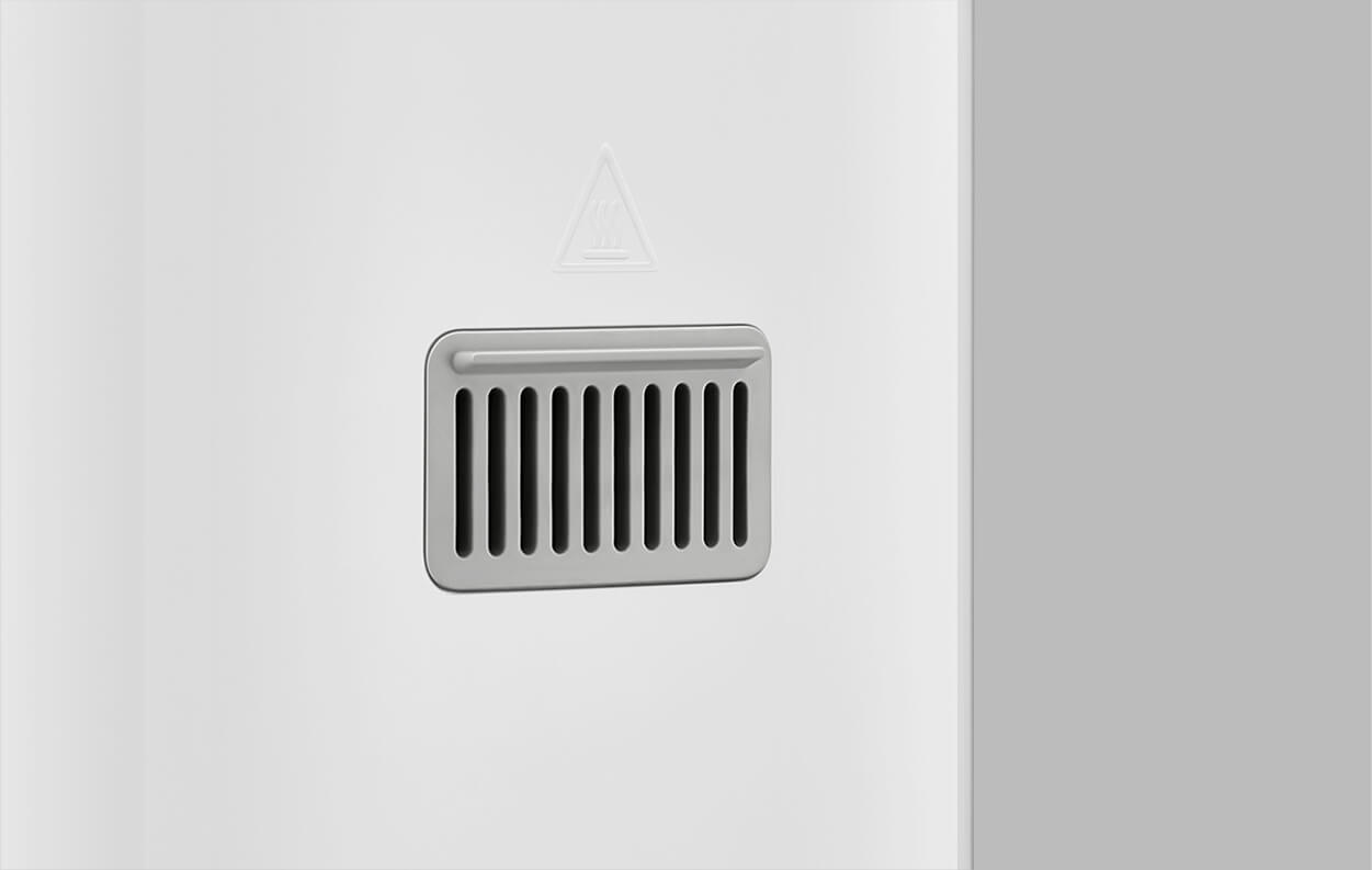 Una rejilla de ventilación gris en una pared blanca con un símbolo de calor encima.