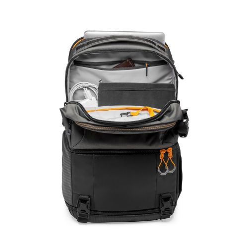 Ein offener dunkelgrauer und schwarzer Rucksack mit orangen Akzenten, Kabeln, einer Tasche und einem Laptop vor weißem Hintergrund.