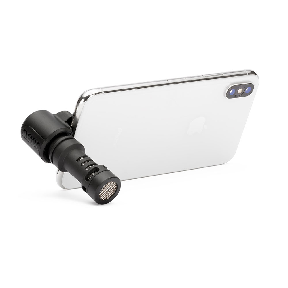 Un microfono Rode nero è collegato alla parte inferiore di uno smartphone bianco.