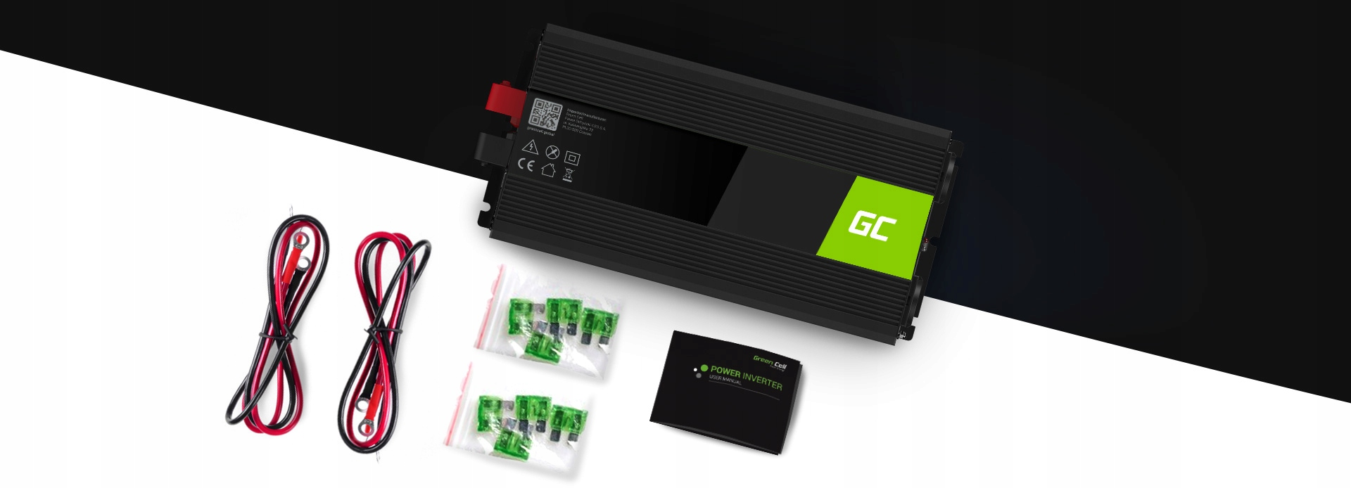 Ein Green Cell Wechselrichter, schwarze und rote Kabel, grüne Sicherungen in Tüten und ein Handbuch auf schrägem Grund.