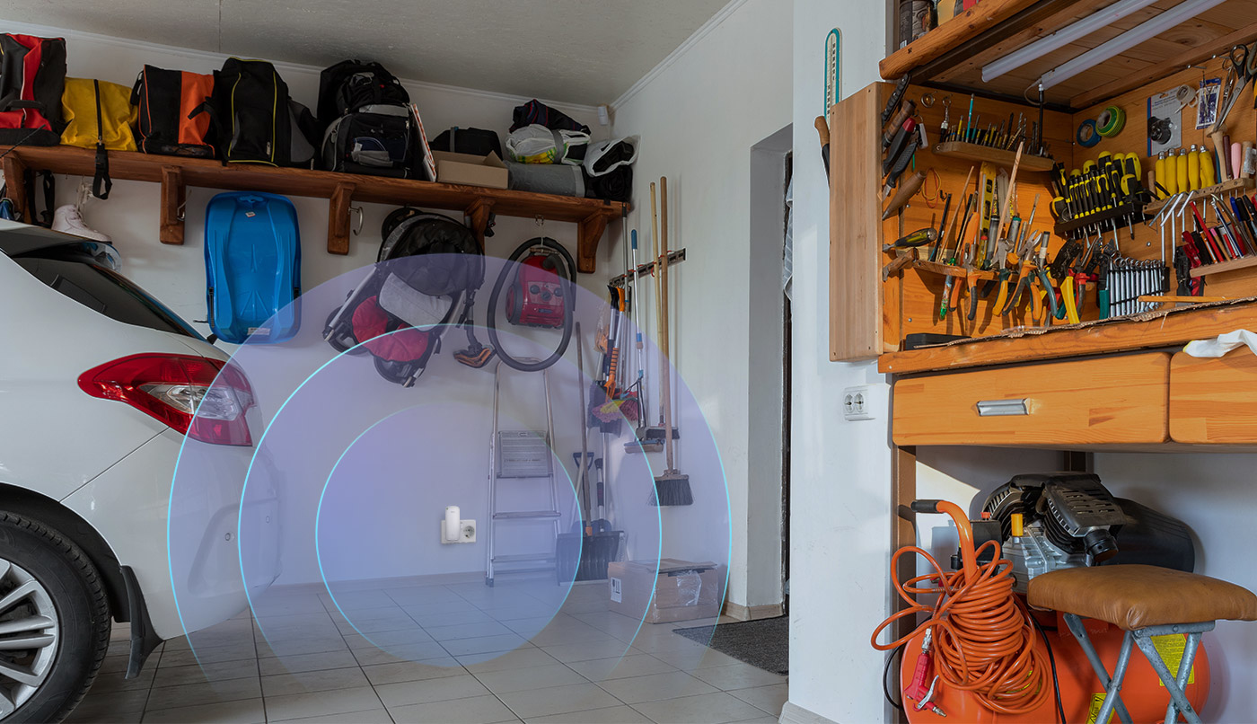 Garage con un'auto bianca, un banco da lavoro e un'icona di segnale Wi-Fi sul muro.