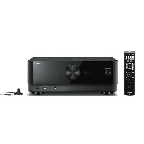 Schwarzer Yamaha AV-Receiver mit großem Drehregler, Display, Fernbedienung und einem kleinen Mikrofon links auf weißem Grund.