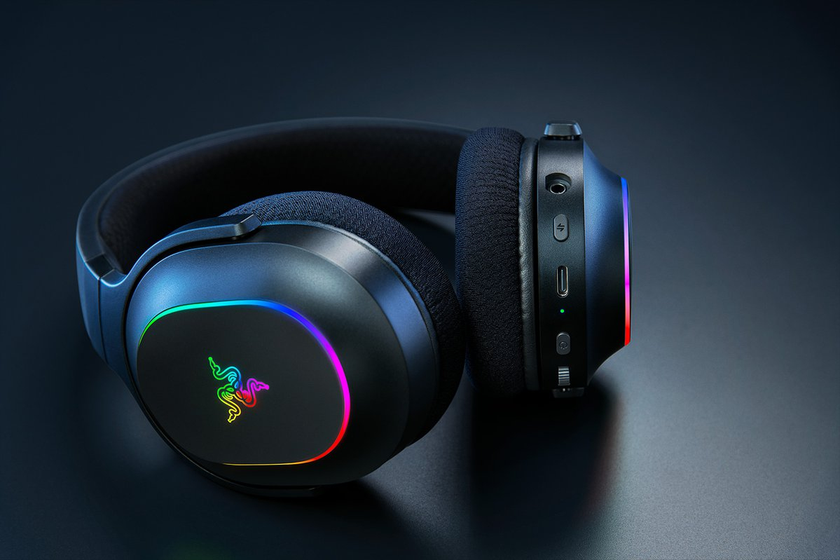Cuffie da gioco nere con illuminazione RGB e pulsanti sul padiglione destro su sfondo scuro.