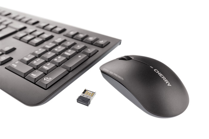 Un teclado negro Cherry, un ratón Cherry y un pequeño receptor USB sobre fondo blanco.