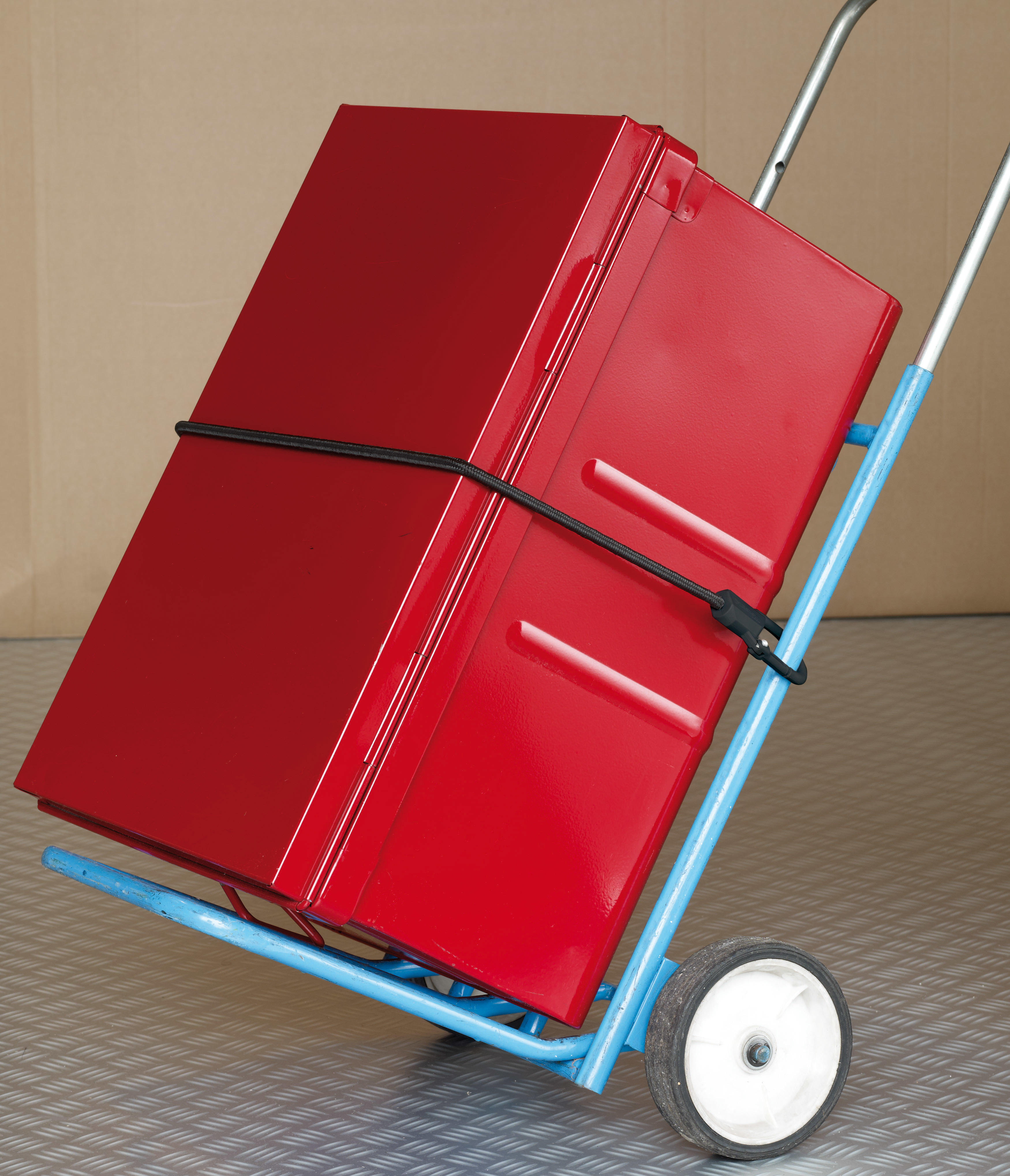 Una scatola di metallo rosso fissata con un cordino elastico nero su un carrello blu.