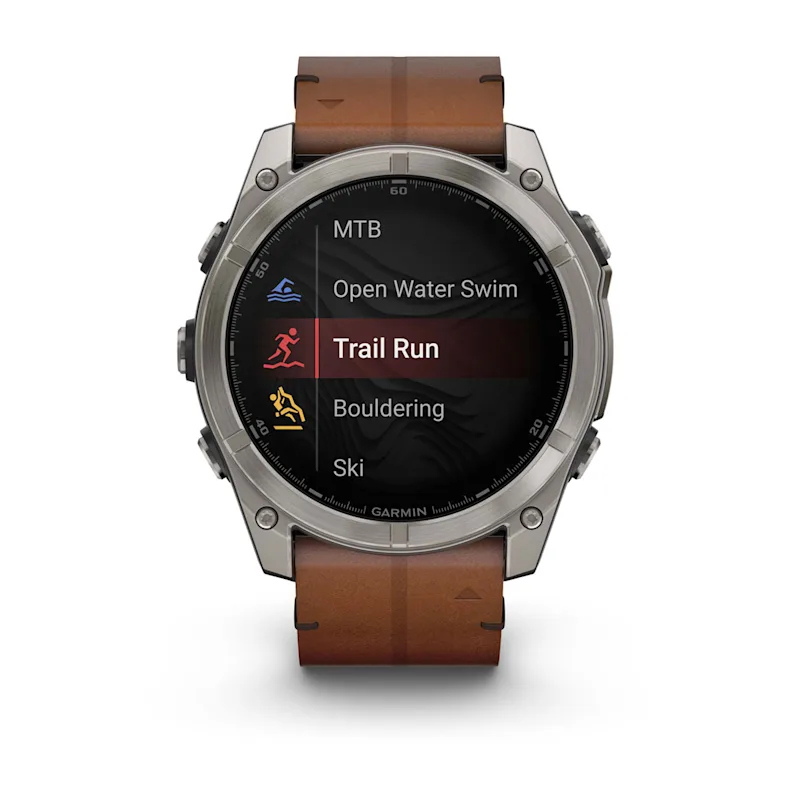 Deri kayışlı bir Garmin spor saat, Trail Run seçeneği vurgulanmış olarak etkinlik menüsünü gösterir.