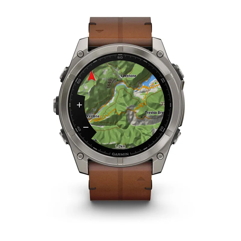 Kahverengi deri kayışlı bir Garmin akıllı saat, ekranında topoğrafik harita gösteriyor.