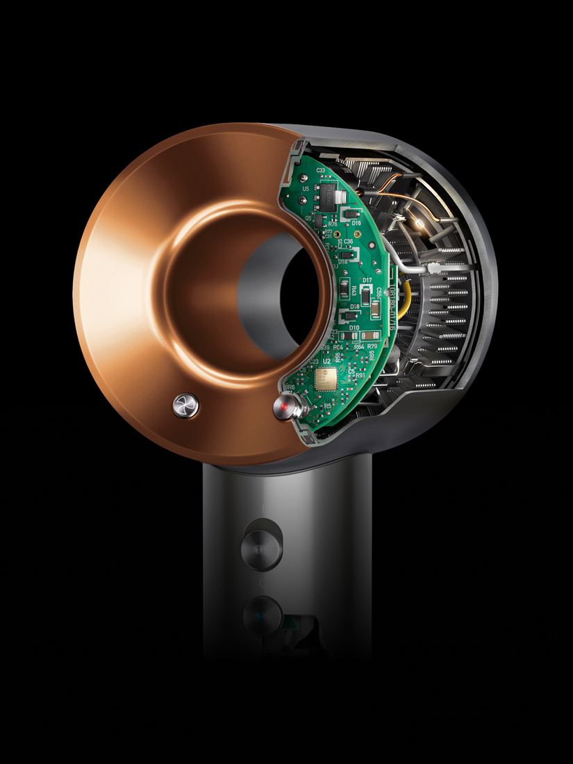Querschnitt eines modernen Haartrockners mit sichtbarer grüner Platine und kupferfarbenem Ring.