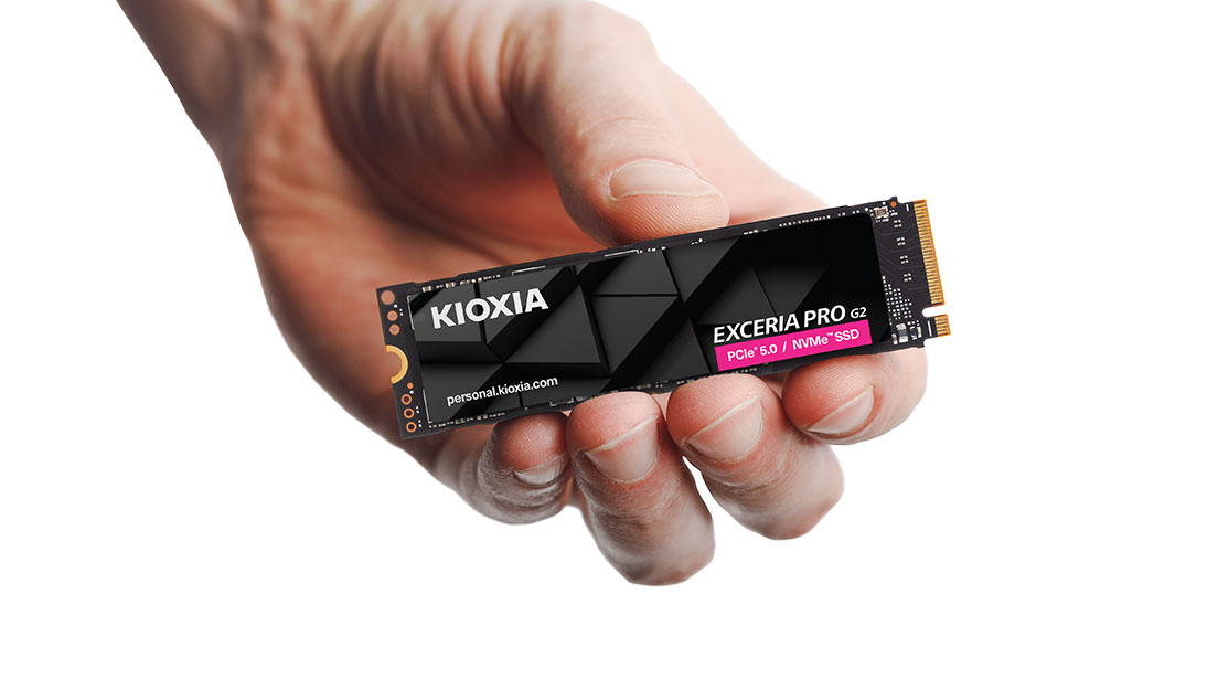 A hand holds a black Kioxia Exceria Pro G2 SSD against a white background.