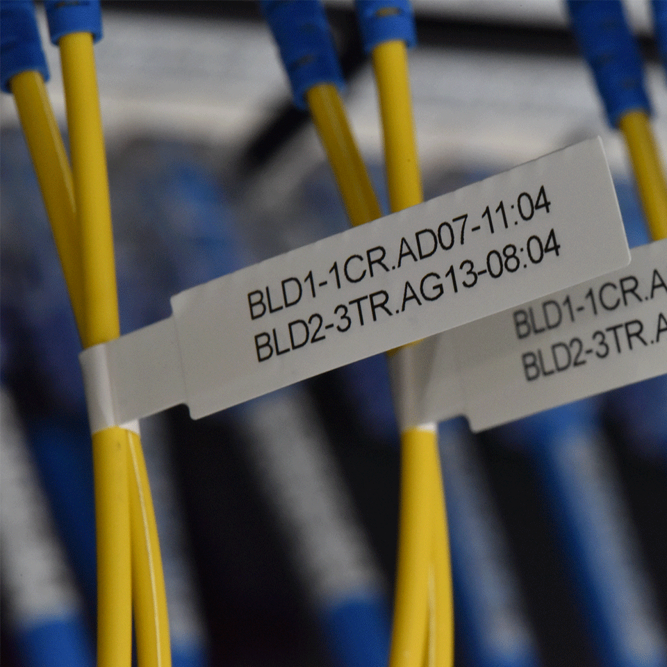 Gelbe Kabel mit blauen Anschlüssen und weißen Etiketten mit Text.
