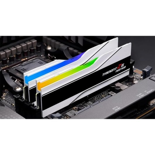Due stick di RAM Trident Z5 Neo RGB bianchi con luci blu, verdi e gialle luminose installati su una scheda madre.