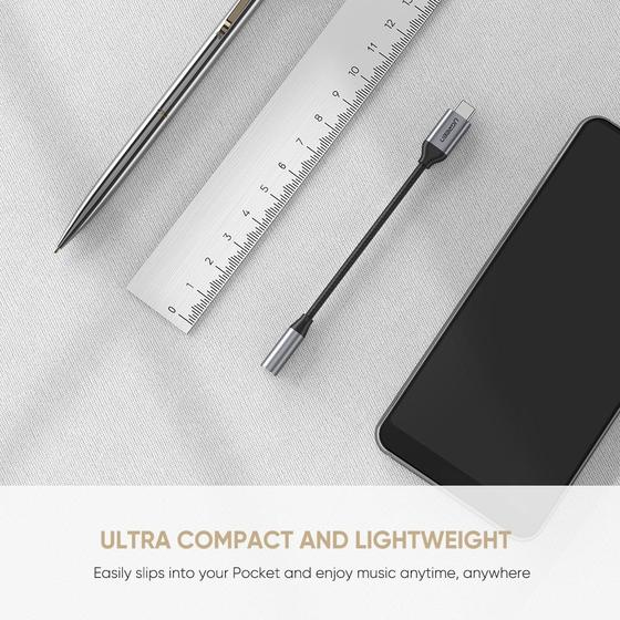 Adapter USB-C, długopis, linijka i smartfon leżą na jasnej powierzchni.