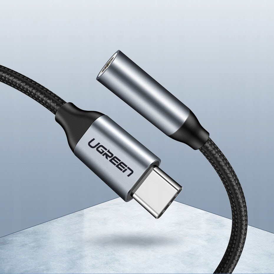 Szary kabel USB-C marki Ugreen z wtykiem i gniazdem na niebieskim tle.