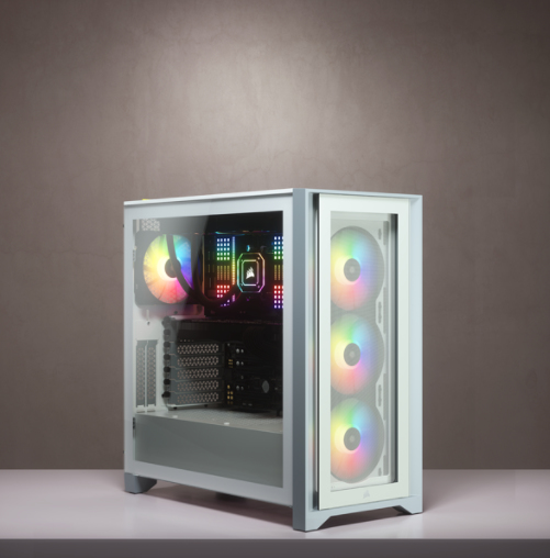 Ein weißes PC-Gehäuse mit Glasseiten und bunten RGB-Lüftern steht auf einem Tisch vor grauer Wand.