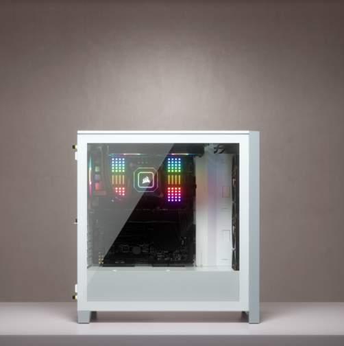 Ein weißes PC-Gehäuse mit Glas-Seitenwand, die bunte RGB-beleuchtete Innenkomponenten auf einer Oberfläche zeigt.
