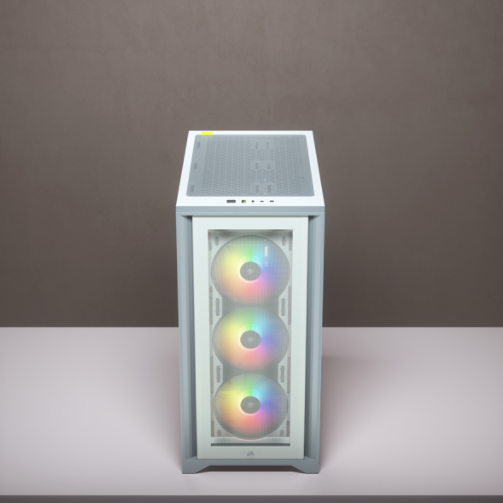 Ein weißes PC-Gehäuse mit drei RGB-Lüftern steht auf einer Tischplatte vor einer grauen Wand.