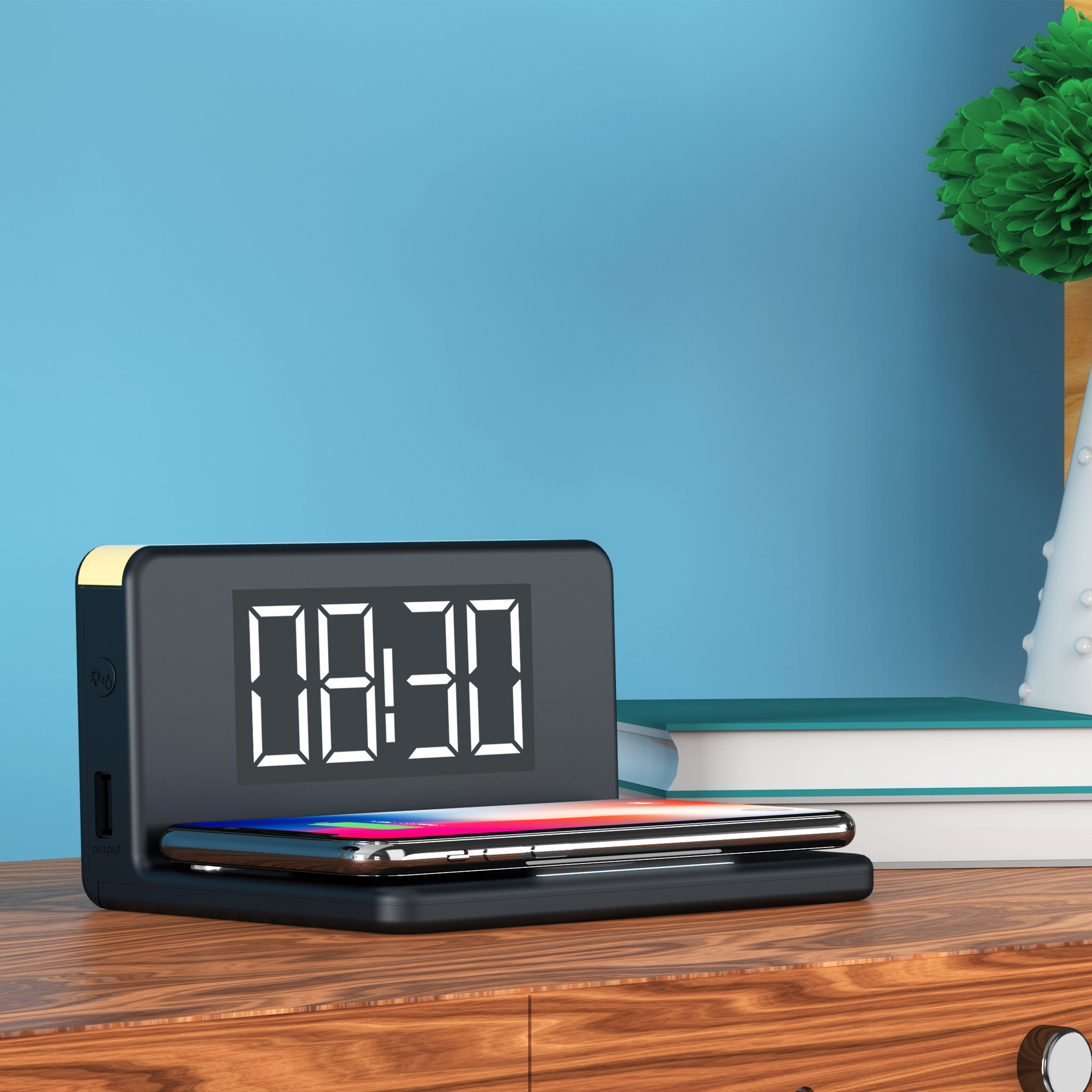 A black digital alarm clock with a smartphone charging on its base sits on a wooden table against a blue wall.