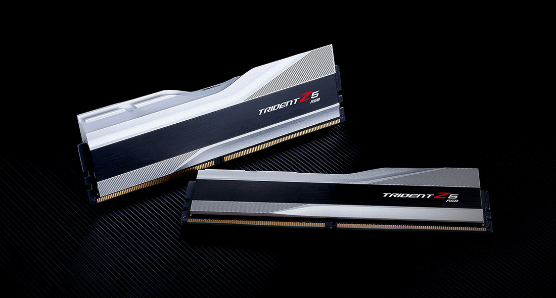 Dwa srebrno-czarne moduły RAM Trident Z5 RGB na czarnym tle.
