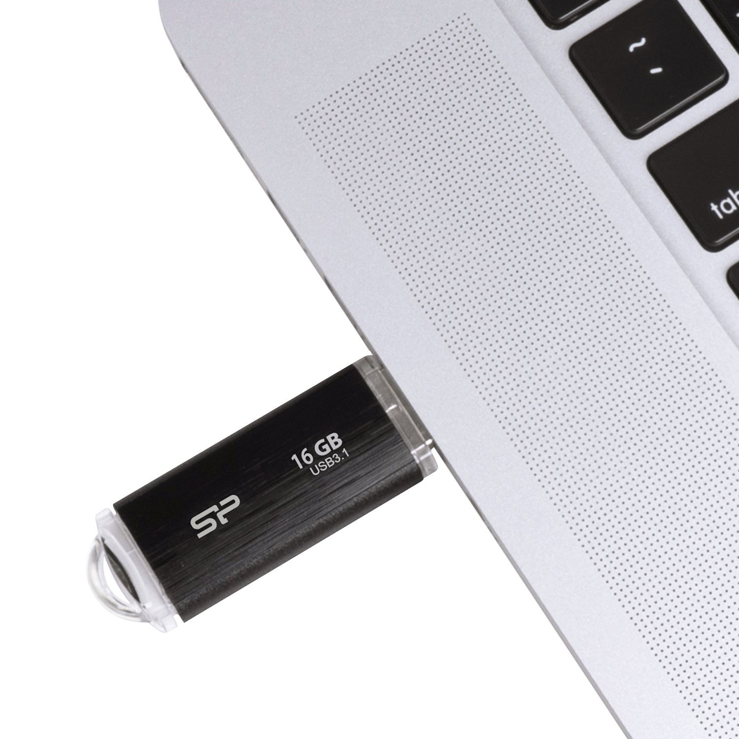 A black 16GB USB flash drive is plugged into the USB port of a silver laptop.