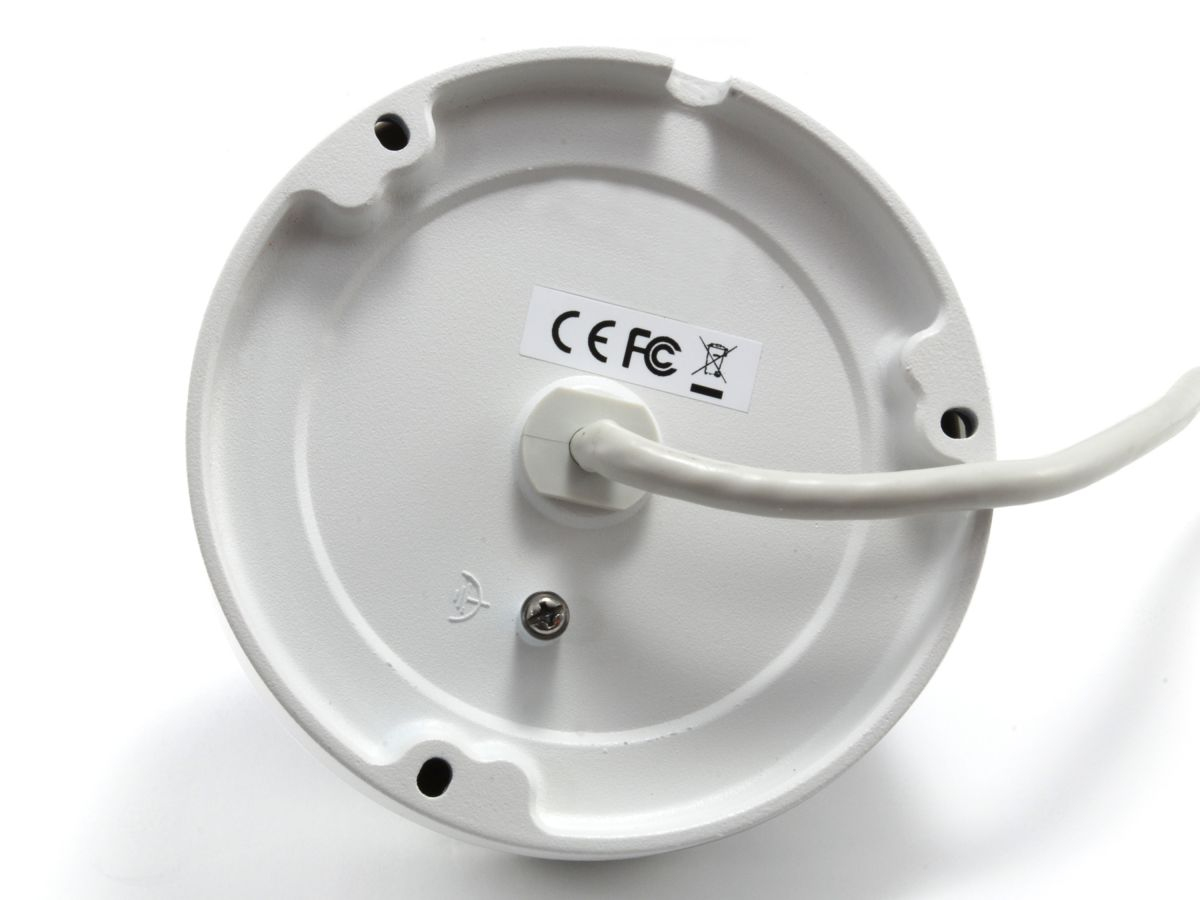 Parte inferiore di un involucro metallico bianco rotondo con etichette CE e FCC, cavo e viti su sfondo bianco.