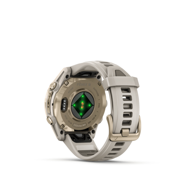 Vista posteriore di uno smartwatch Garmin Fenix beige con sensori su sfondo bianco.