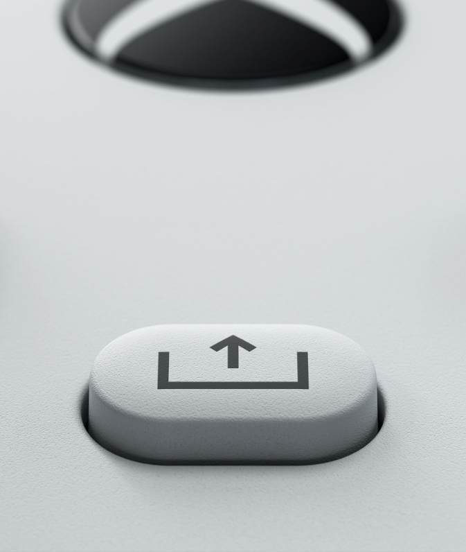 Nahaufnahme einer weißen Share-Taste mit Pfeilsymbol auf einer grauen Controller-Oberfläche.