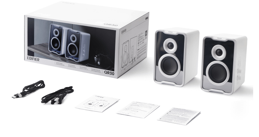 Altavoces blancos Edifier QR30 con caja, cables y manuales sobre fondo blanco.