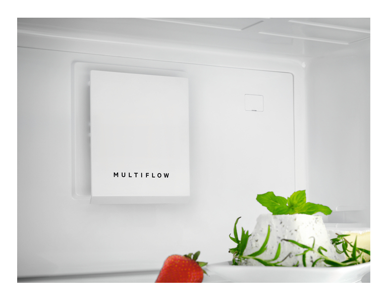 Interior de refrigerador blanco con etiqueta Multiflow, fresa y hierbas frescas.