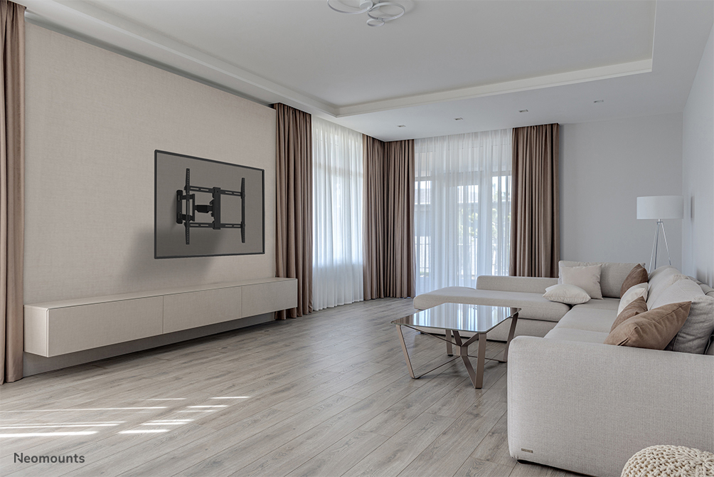 Wohnzimmer mit hellem Sofa, Glastisch, TV-Wandhalterung und bodentiefen Fenstern.