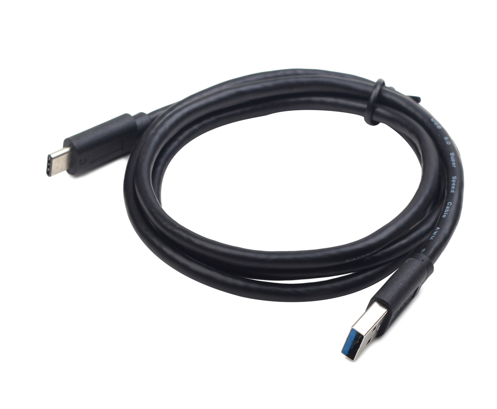 A coiled black USB-C to USB-A cable rests on a white background.