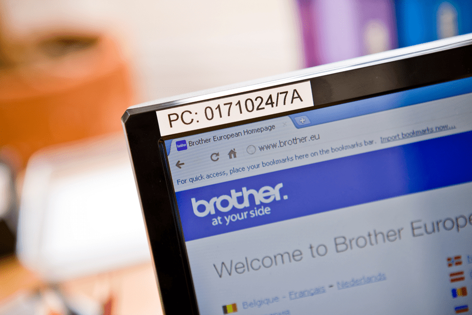 Ein Computerbildschirm zeigt die Brother-Website, oben ist ein Etikett mit der Aufschrift PC: 0171024/7A.