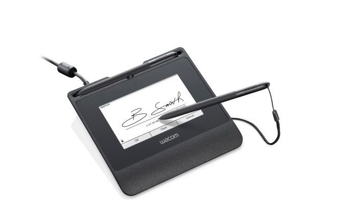 Ein schwarzes Wacom-Signaturpad zeigt eine Unterschrift auf dem Bildschirm, mit einem Stift auf dem Display.
