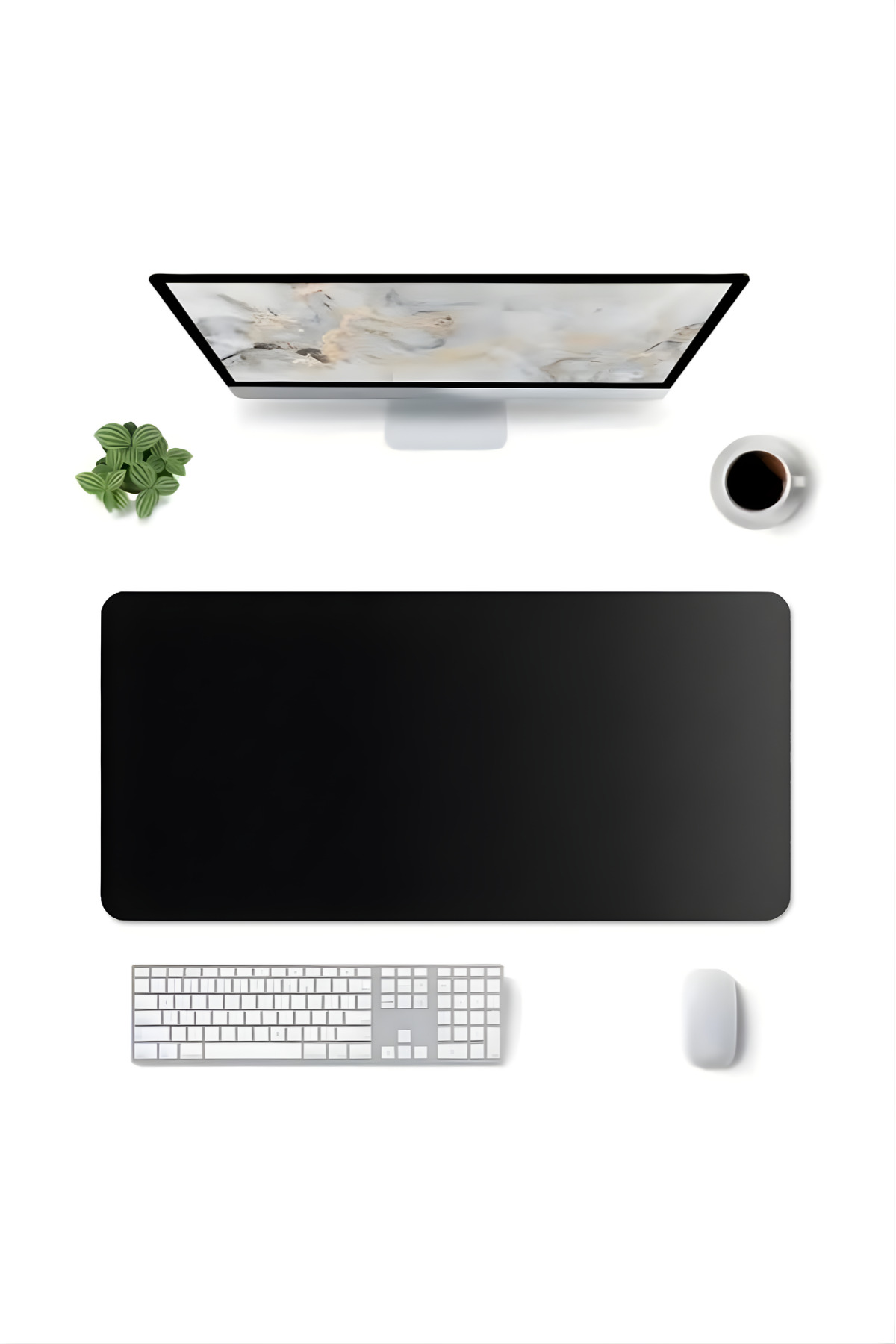 Monitör, siyah mousepad, beyaz klavye, fare, kahve fincanı ve bitki olan bir masanın yukarıdan görünümü.