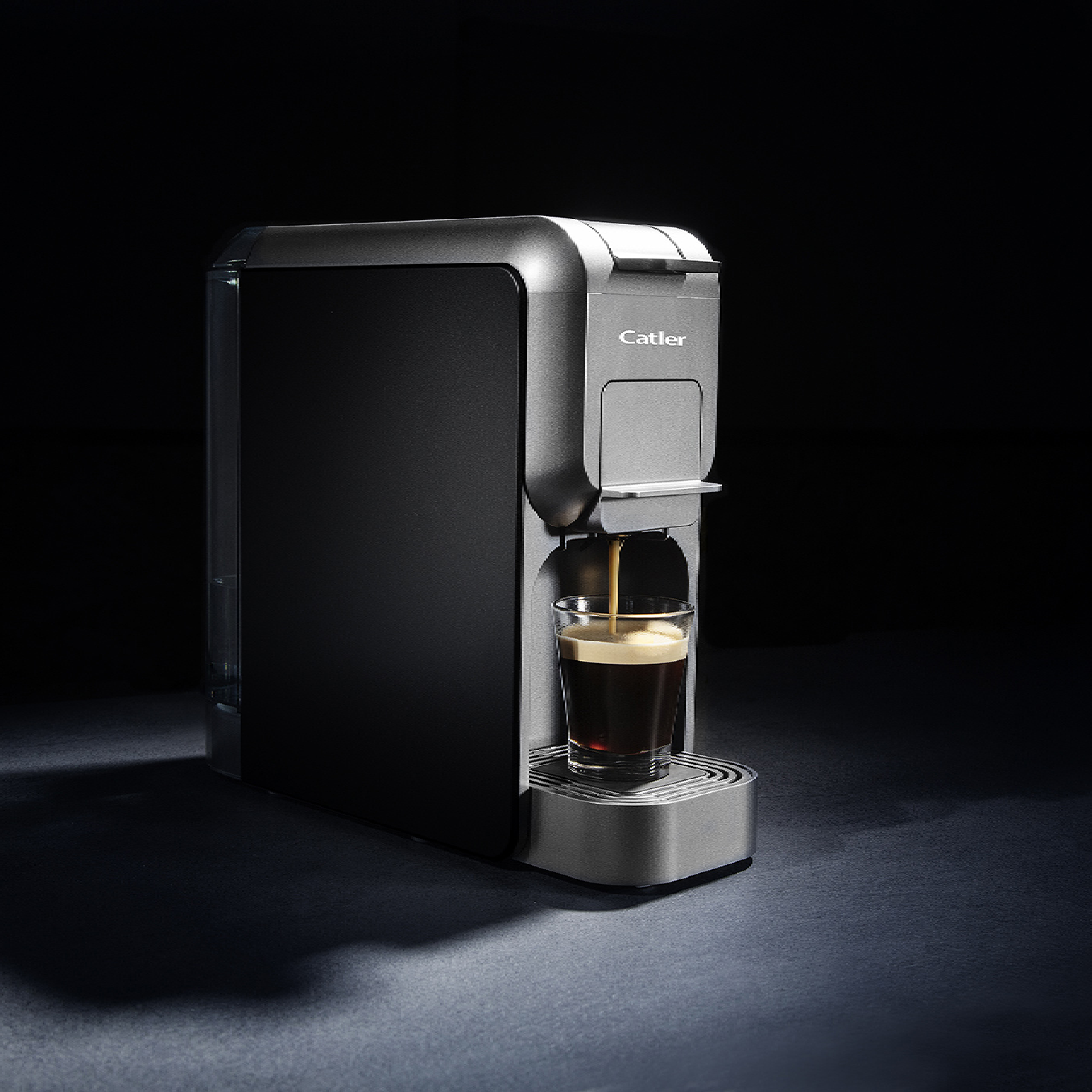 Eine schwarze und silberne Catler Kaffeemaschine brüht Espresso in ein kleines Glas auf dunklem Hintergrund.