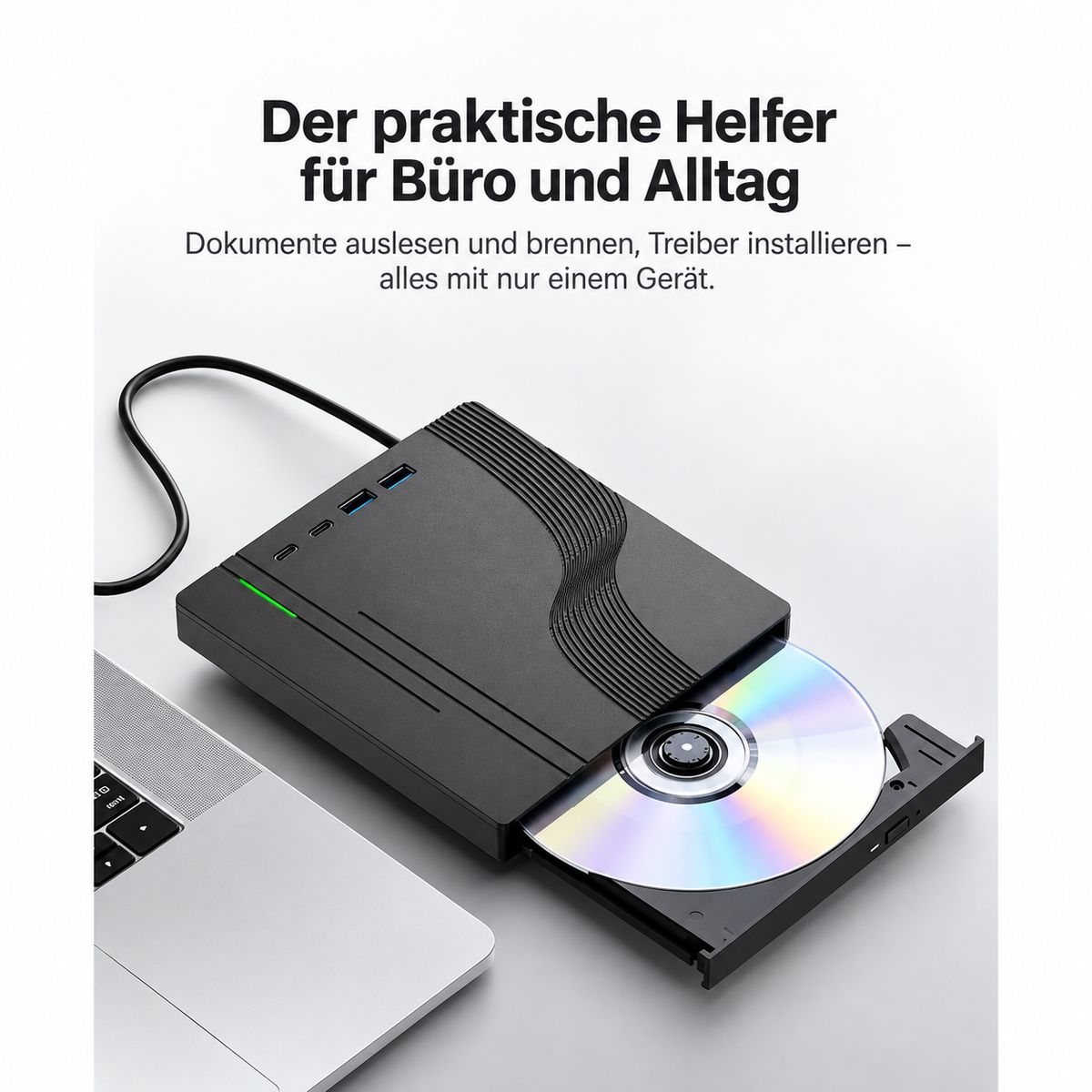 Schwarzes externes Laufwerk mit offener Schublade und CD, neben einem Laptop auf hellem Tisch.