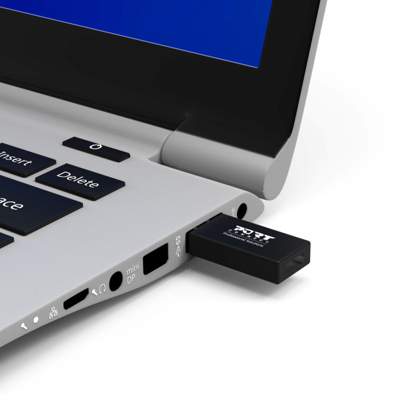 Ein schwarzer USB-Stick steckt im seitlichen Anschluss eines silbernen Laptops.