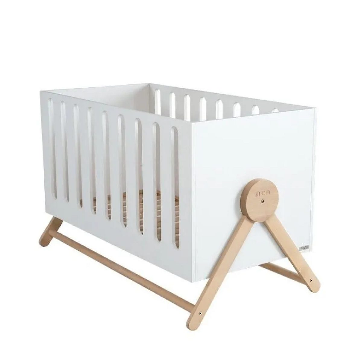 Ein weißes Babybett mit Holzbeinen vor weißem Hintergrund.
