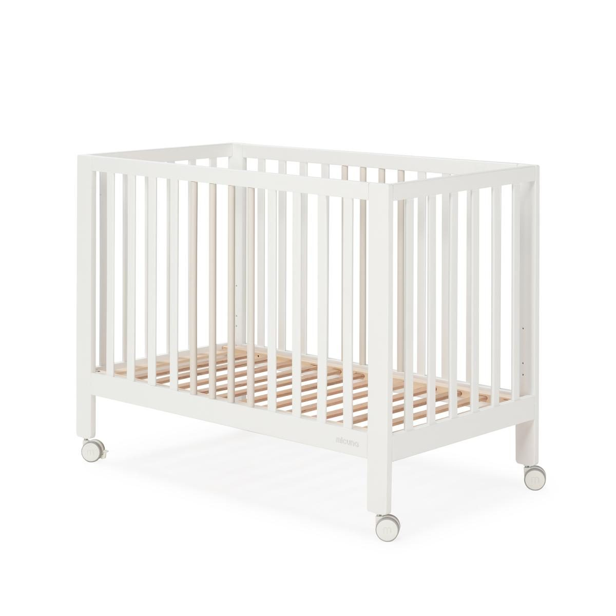 Weißes Babybett aus Holz mit Rollen auf weißem Hintergrund.