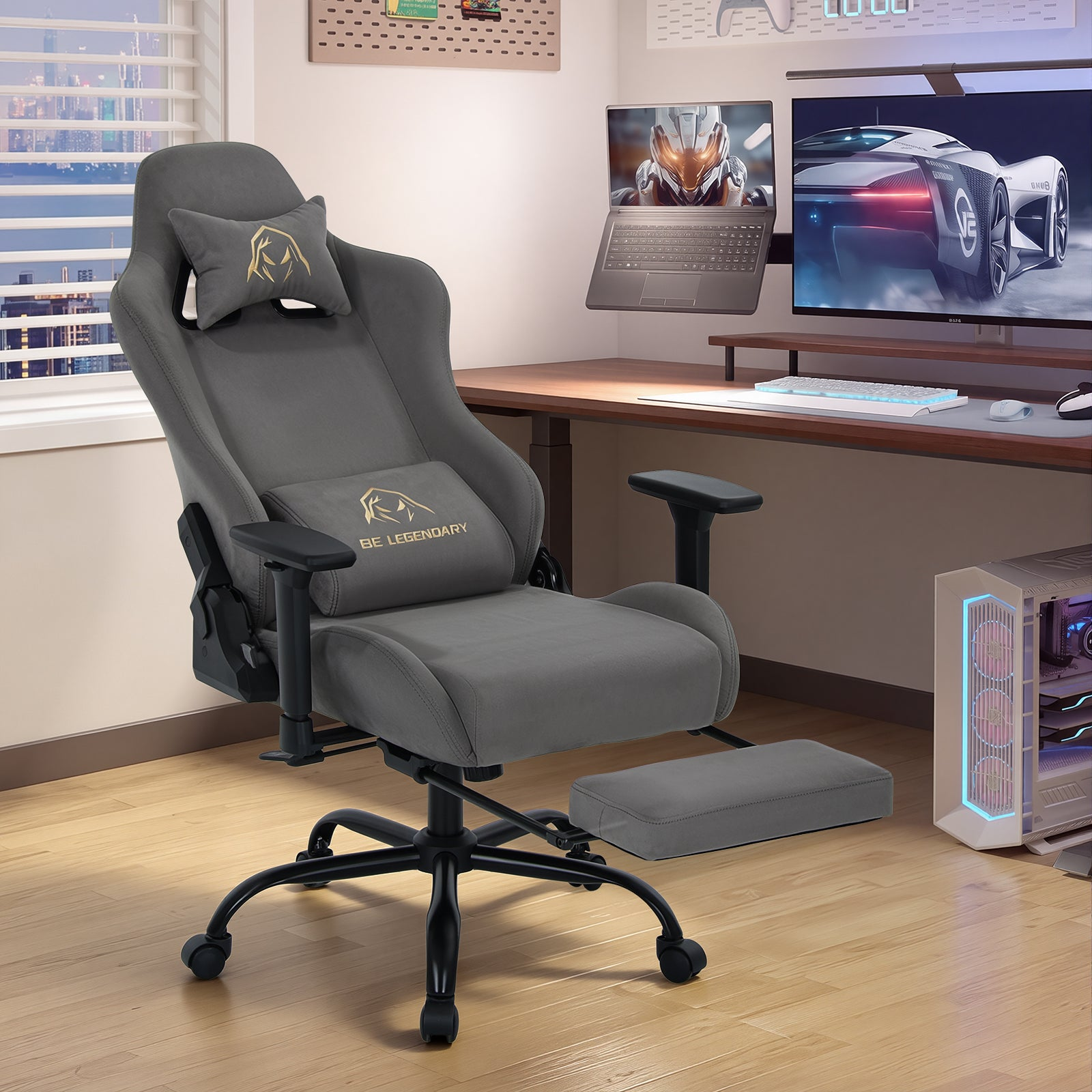 Grauer Gaming-Stuhl mit Fußstütze vor einem Schreibtisch mit Monitoren und PC.