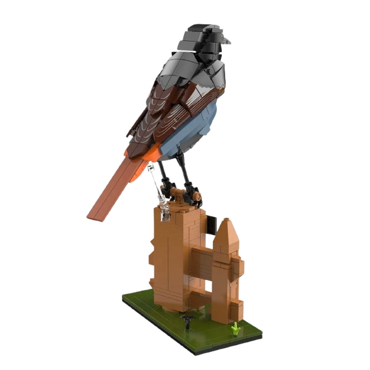 Ein detailliertes Lego-Modell eines Vogels sitzt auf einem braunen Holzzaunpfosten auf einer grünen Basis.