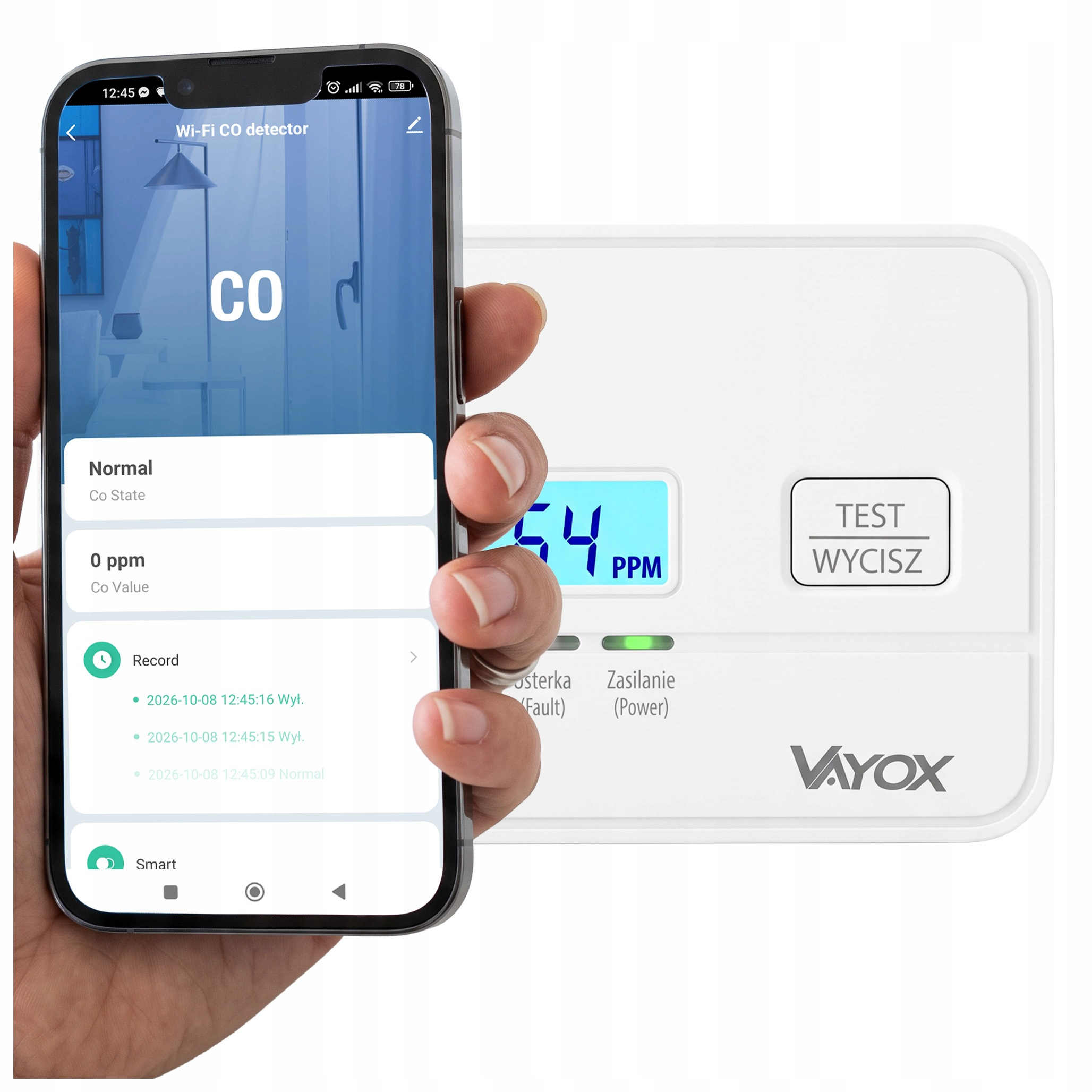 Dłoń trzyma smartfon z aplikacją czujnika czadu, w tle biały detektor Vayox.