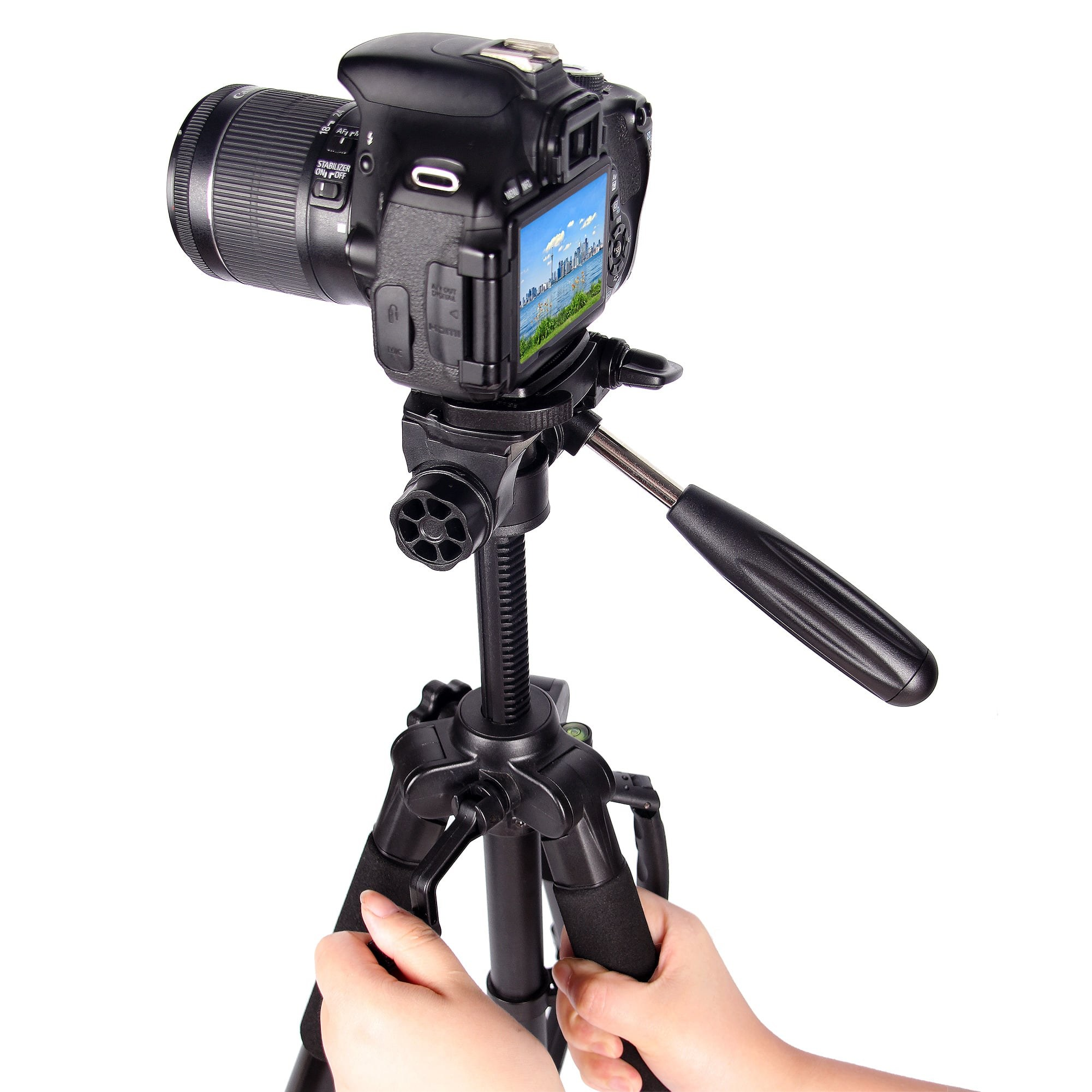 A black DSLR camera mounted on a tripod is held by hands against a white background.
