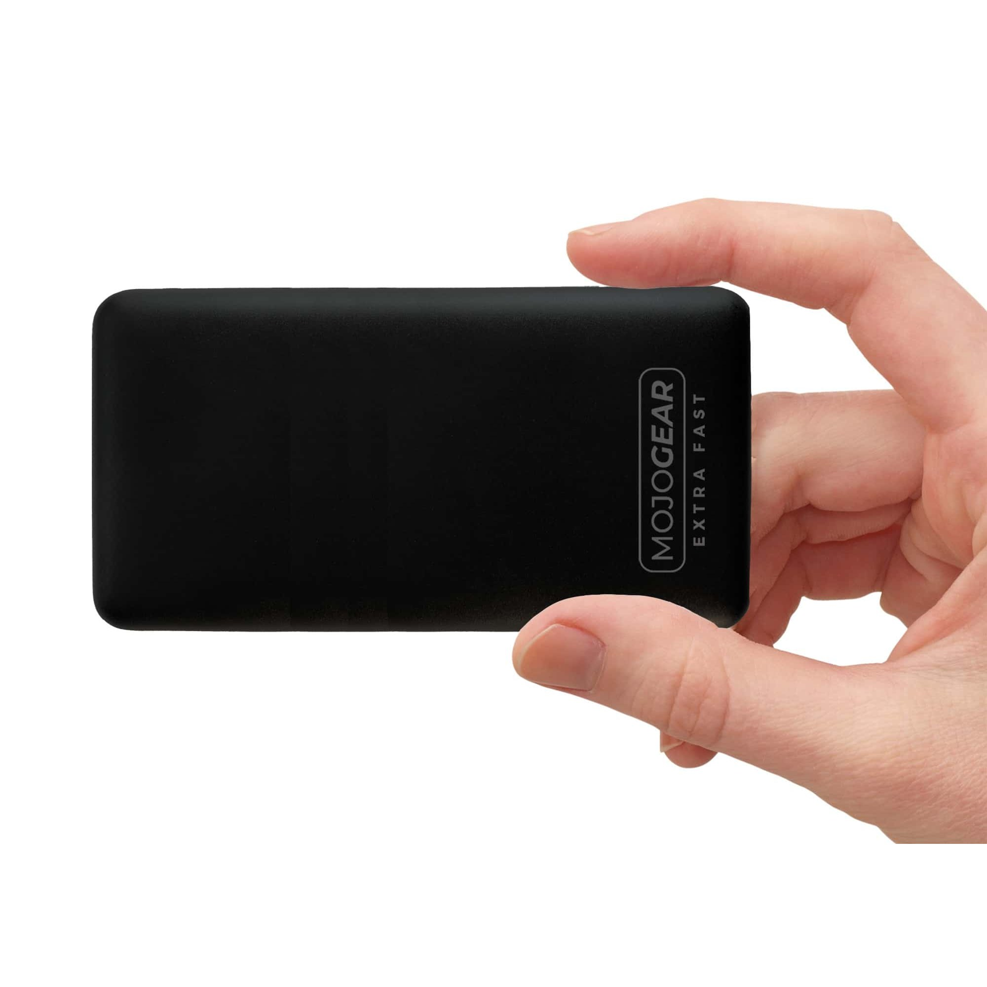 Une main tient une batterie externe noire Mojogear Extra Fast sur fond blanc.
