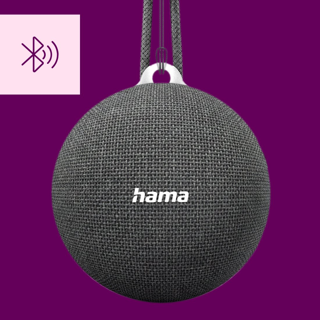 Szary, sferyczny głośnik Bluetooth marki Hama wisi na sznurku na fioletowym tle.