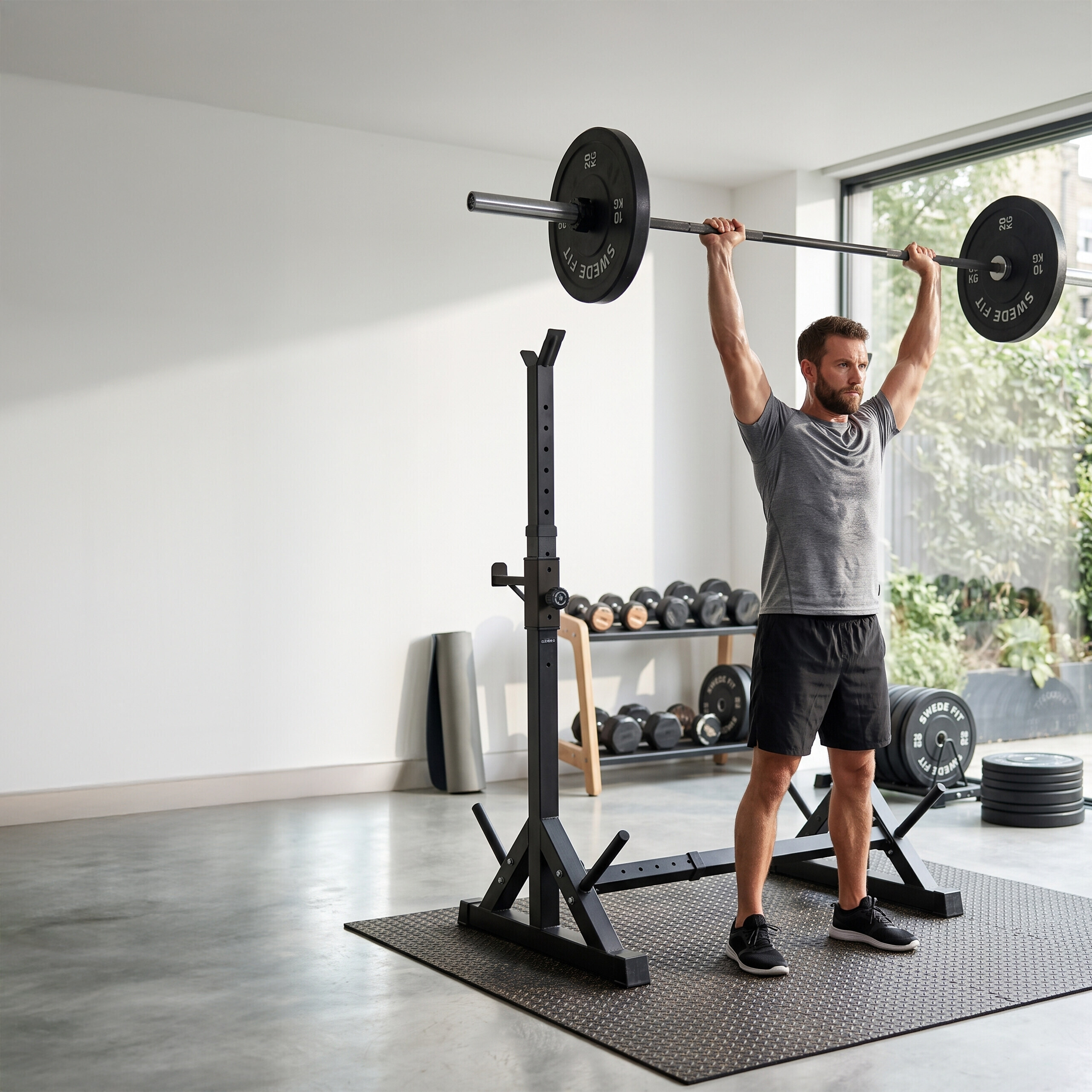Ein Mann hebt eine Langhantel über seinen Kopf in einem Fitnessraum.