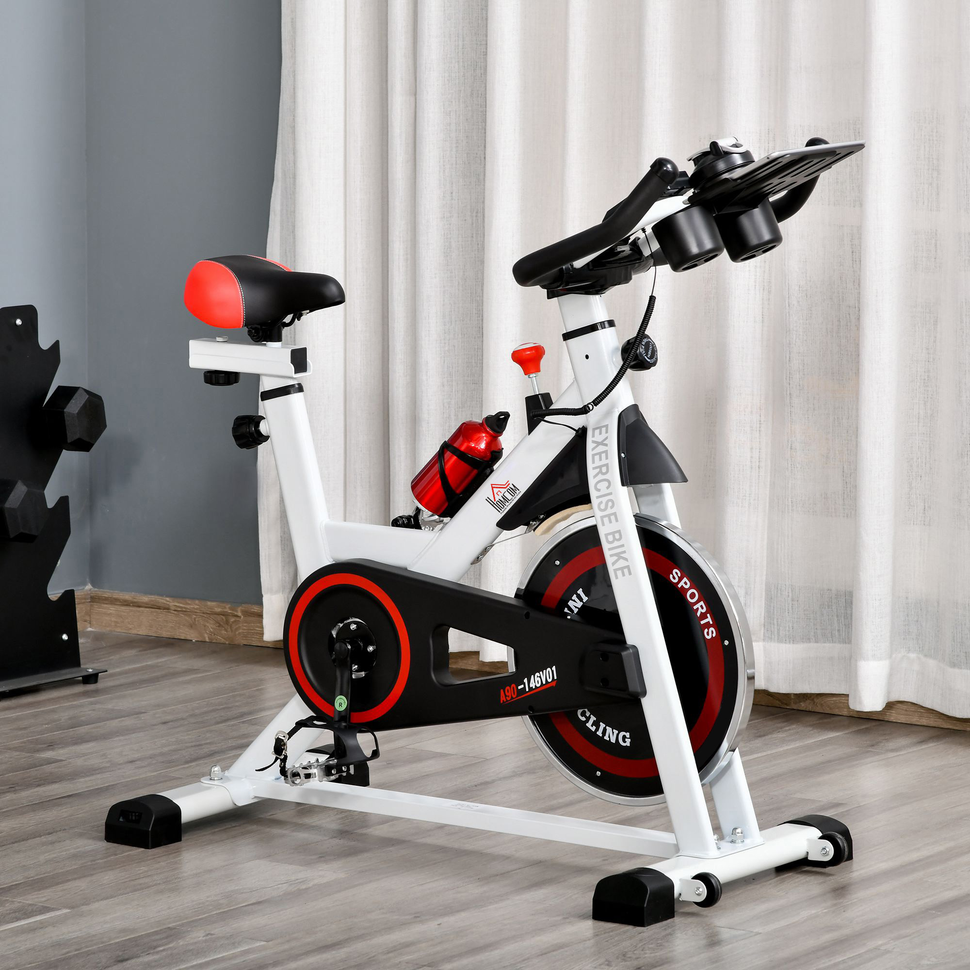 Una cyclette bianca e rossa su pavimento in legno davanti a tende chiare.