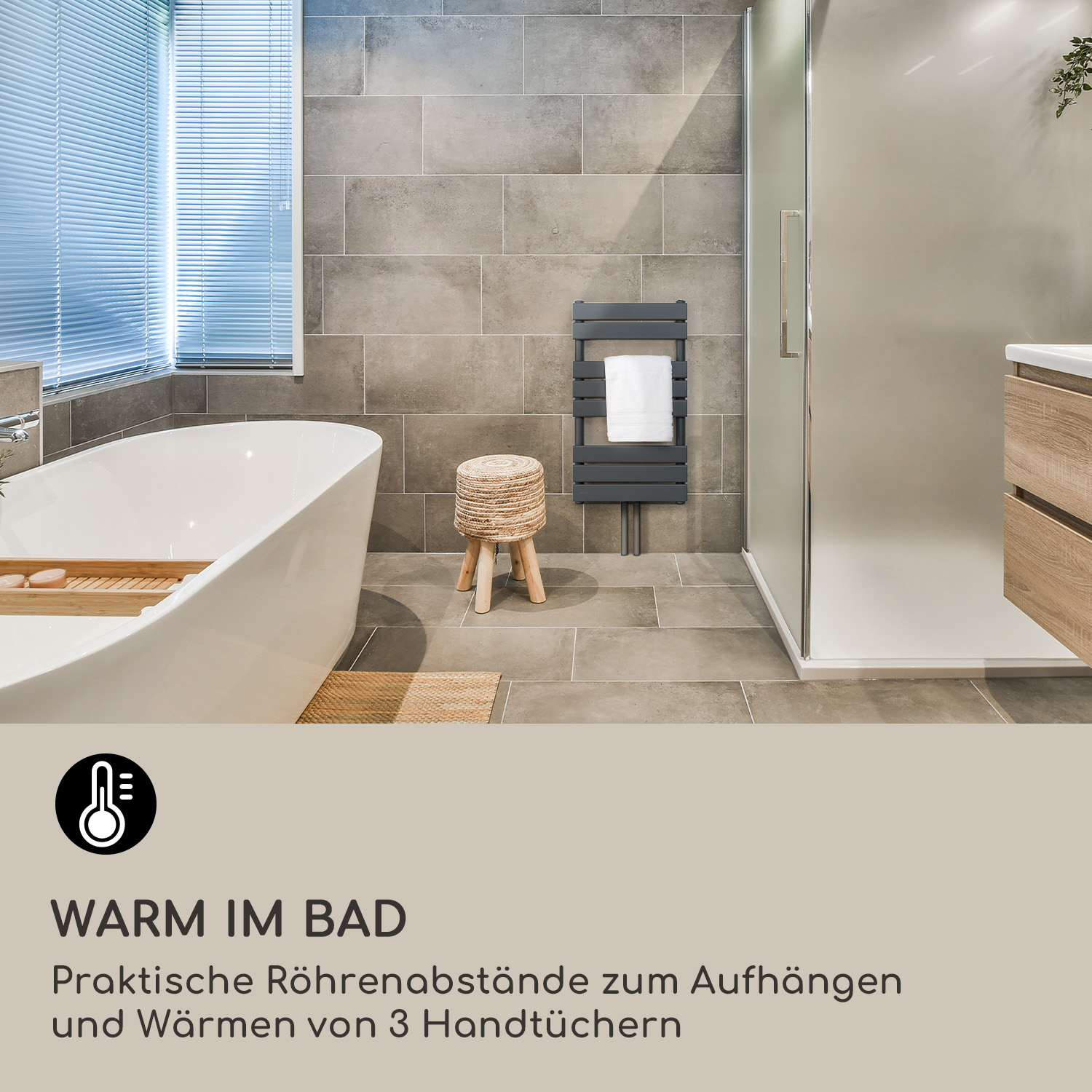 Bagno moderno con vasca freestanding, piastrelle grigie, scaldasalviette grigio scuro e uno sgabello in legno.