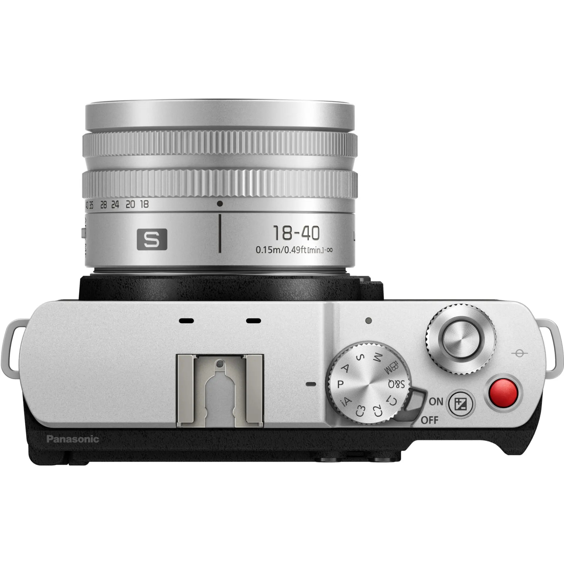 Widok z góry srebrnego aparatu Panasonic z obiektywem 18-40 mm, pokrętłami i czerwonym przyciskiem.