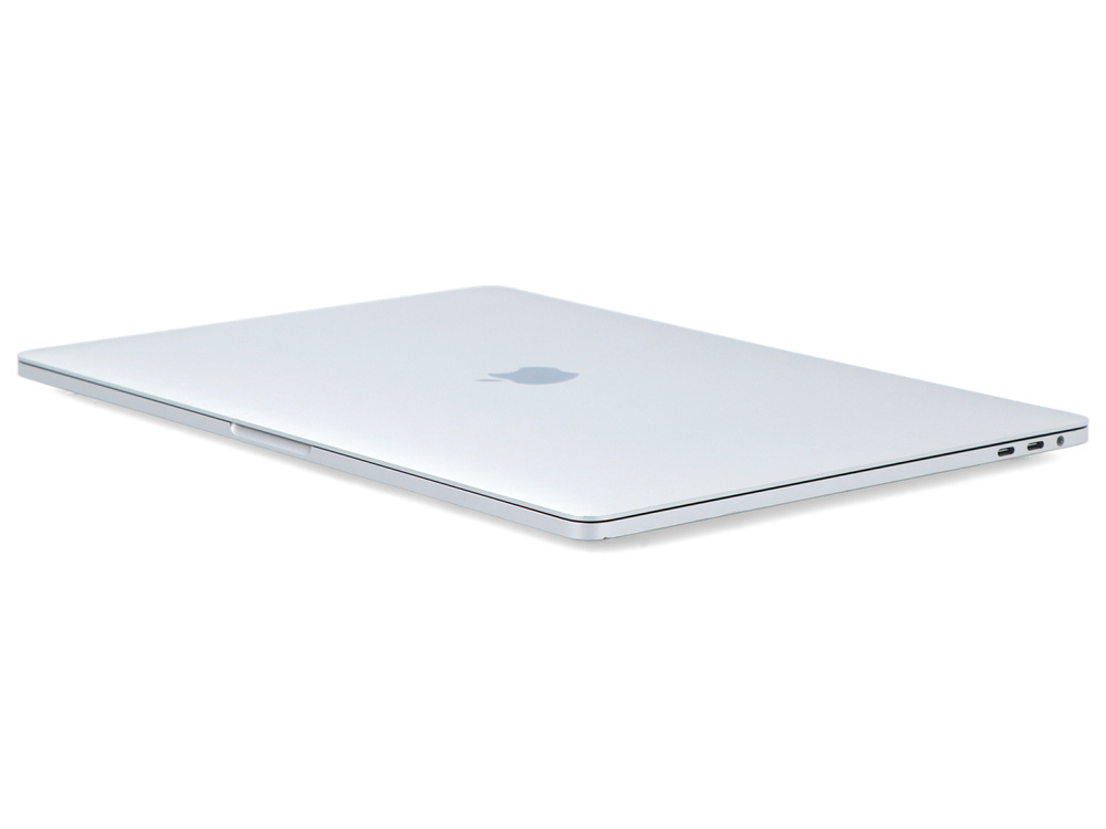 Srebrny, zamknięty laptop spoczywa na białej powierzchni z widocznym logo Apple.
